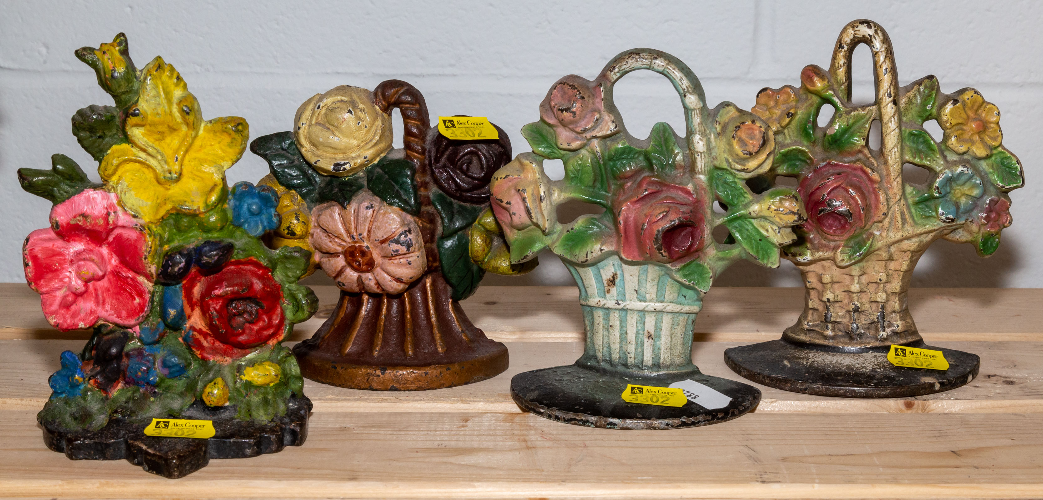 FOUR FLORAL CAST IRON DOOR STOPS