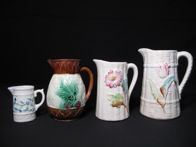 Four Majolica pottery pitchers.