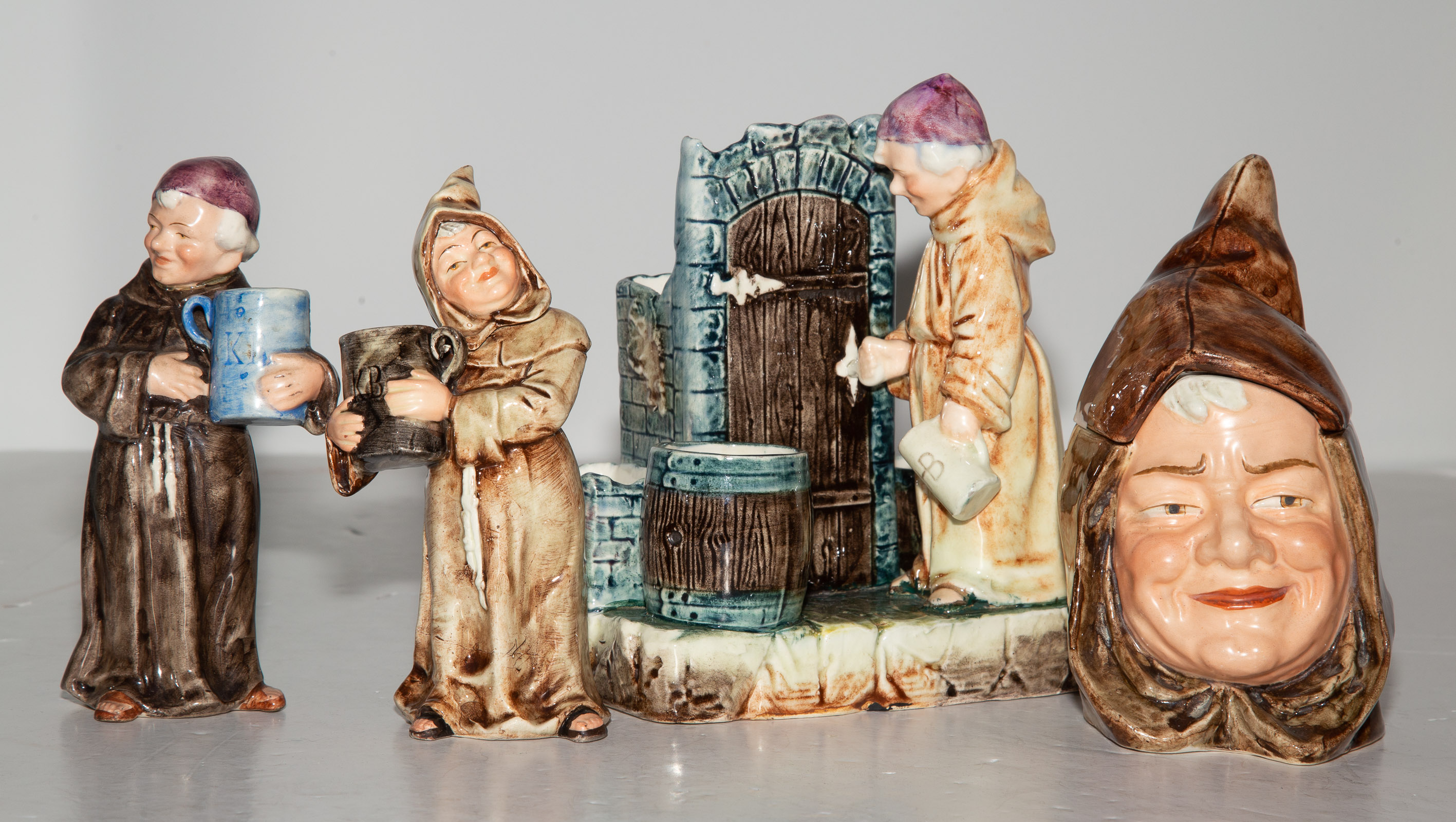 FOUR MONK-THEMED CERAMIC FIGURES