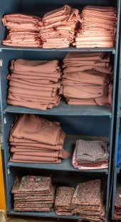 FOUR SHELVES OF TABLE LINENS F