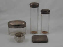 Four silver topped jars and a
