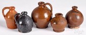FOUR SMALL REDWARE JUGS AND A