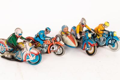 Four tinplate motorcycles, one with