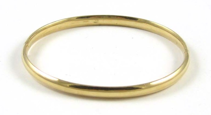 FOURTEEN KARAT GOLD BANGLE. The