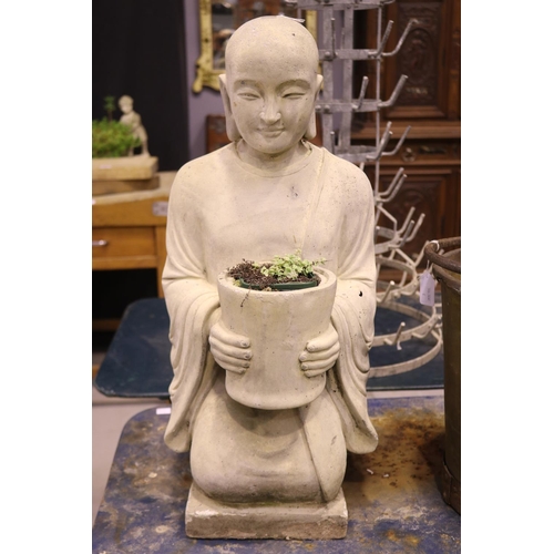 Garden Buddha statue holding a pot,