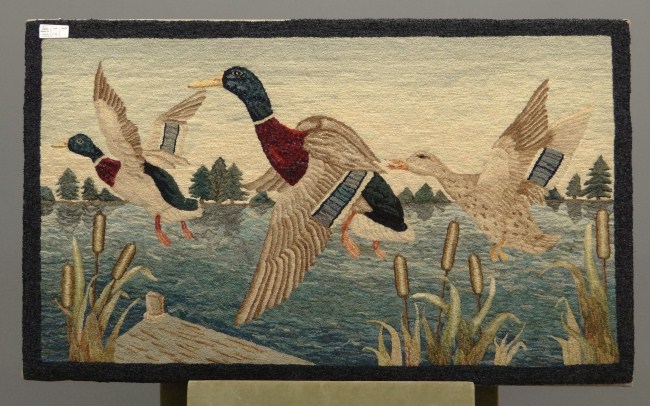 Hooked rug with flying ducks.
