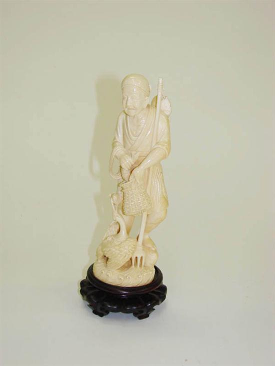 IVORY CARVING OF A FISHERMAN. 