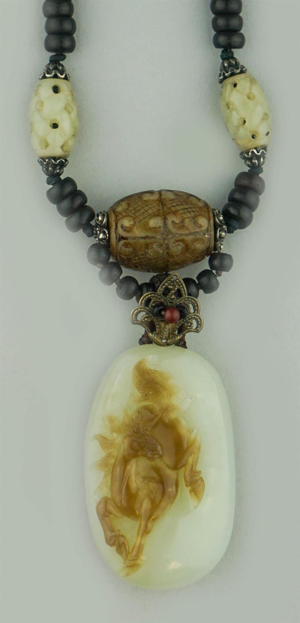 JADE PENDANT ON A WOOD AND JADE