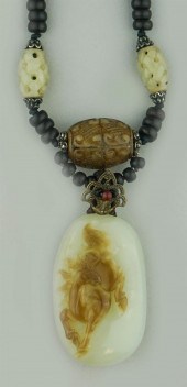 JADE PENDANT ON A WOOD AND JAD