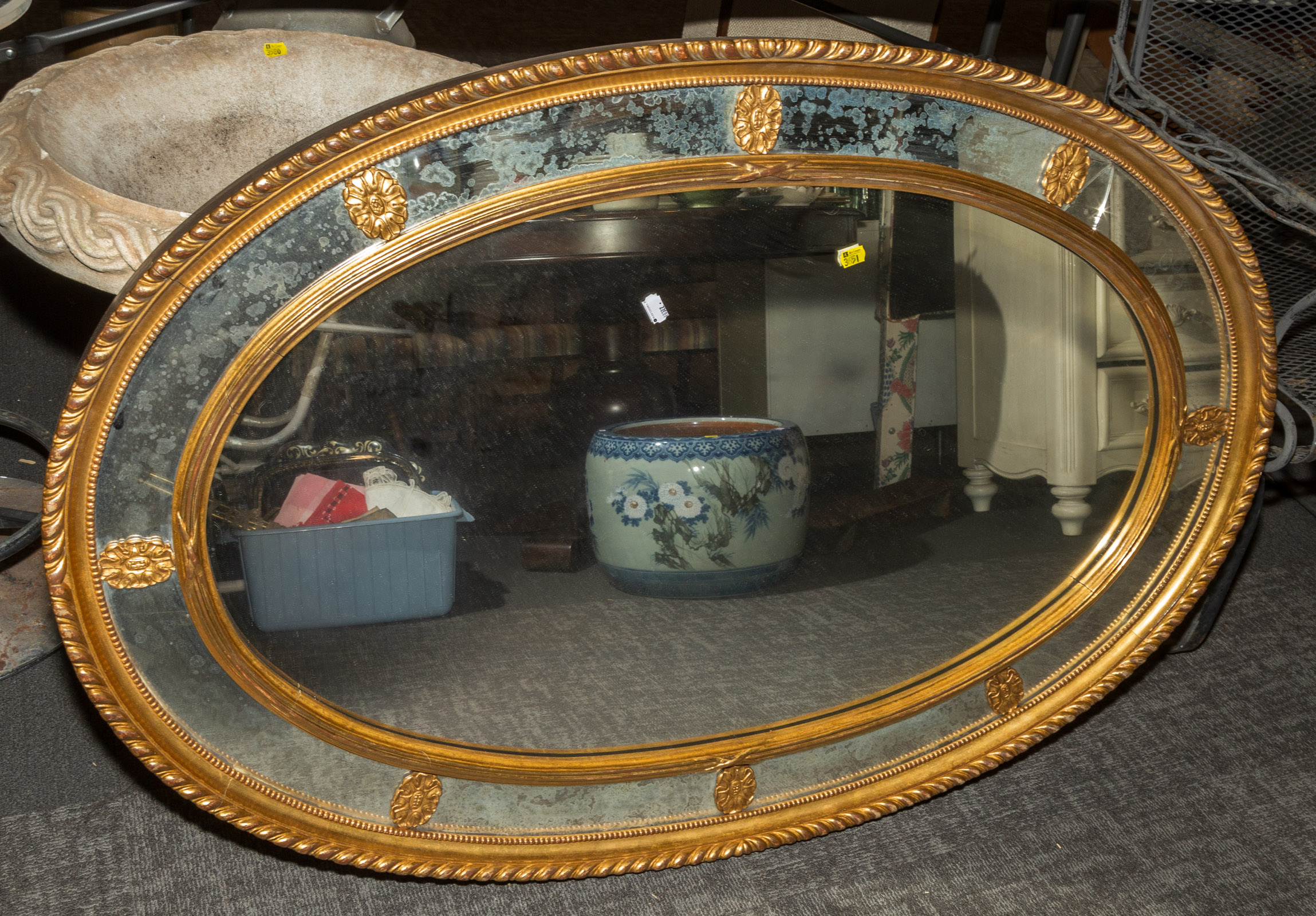 LARGE OVAL GILT FRAMED MIRROR .