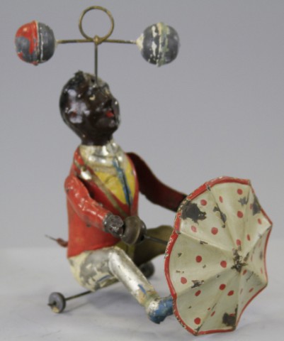 MAN TWIRLING BALLS AND UMBRELLA