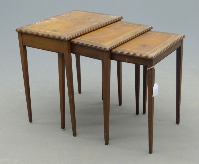 Nest of three leather top tables.