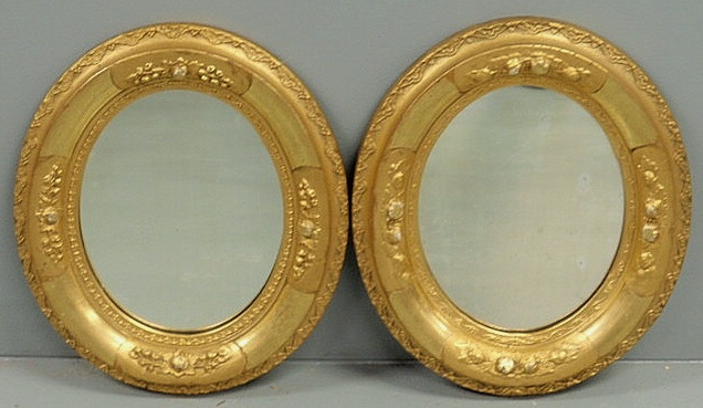 Pair of oval gilt decorated mirrors