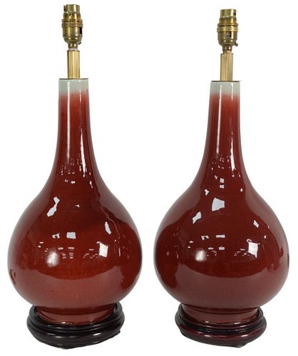 PAIR OF OXBLOOD VASES ON BLACK WOOD