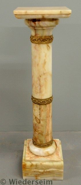 Polished marble pedestal with brass
