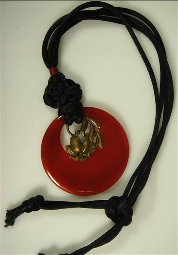 Round carnelian pendant on cord,