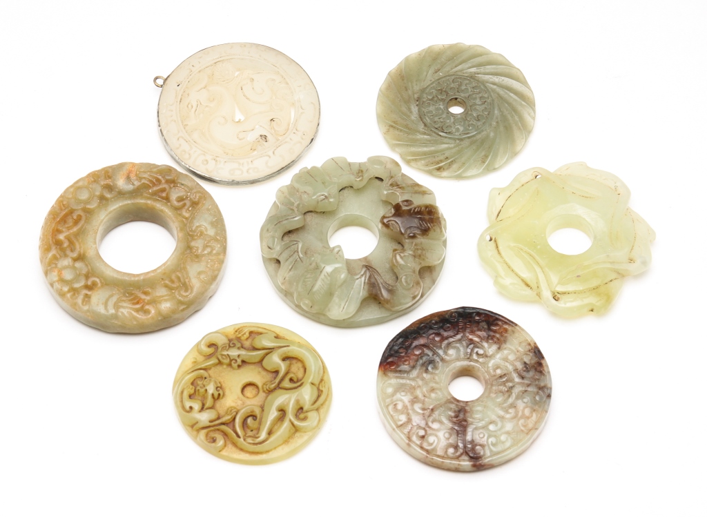 SEVEN ASIAN CARVED STONE DISKS.