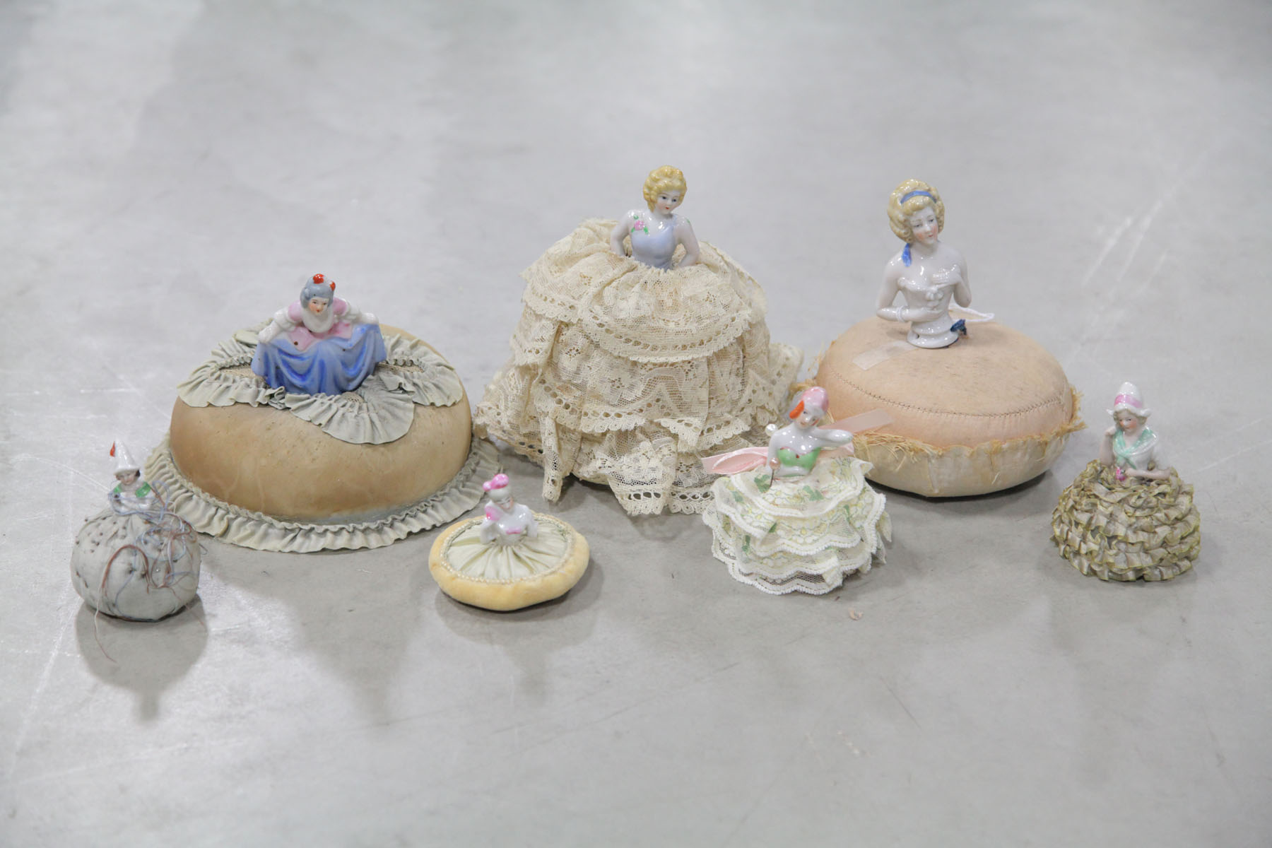 SEVEN DOLL PIN CUSHIONS. 