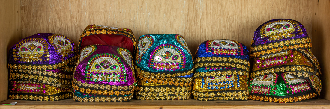 SHELF OF ASIAN EMBROIDERED HATS,