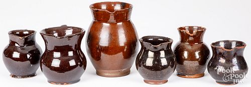 SIX REDWARE PITCHERS, 19TH C.Six