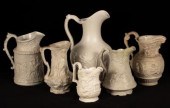 Six saltware jugs, decorated f