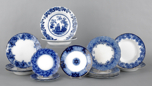 Sixteen flow blue plates and