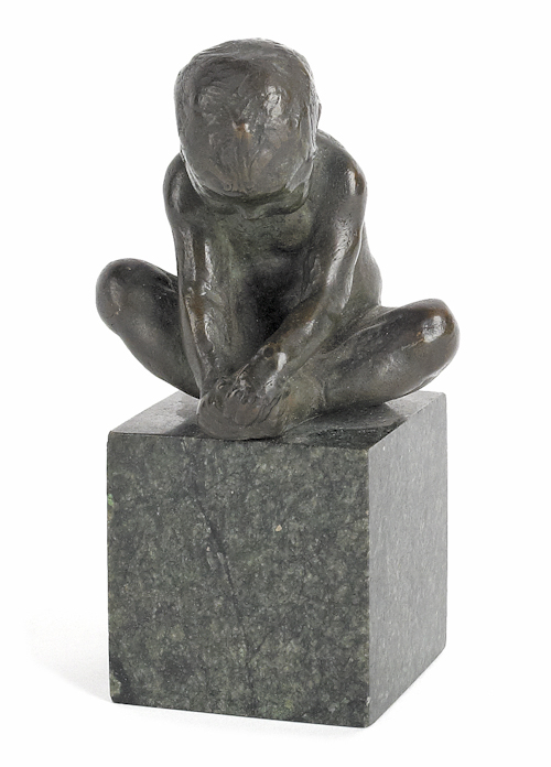 Small bronze of a seated boy on a