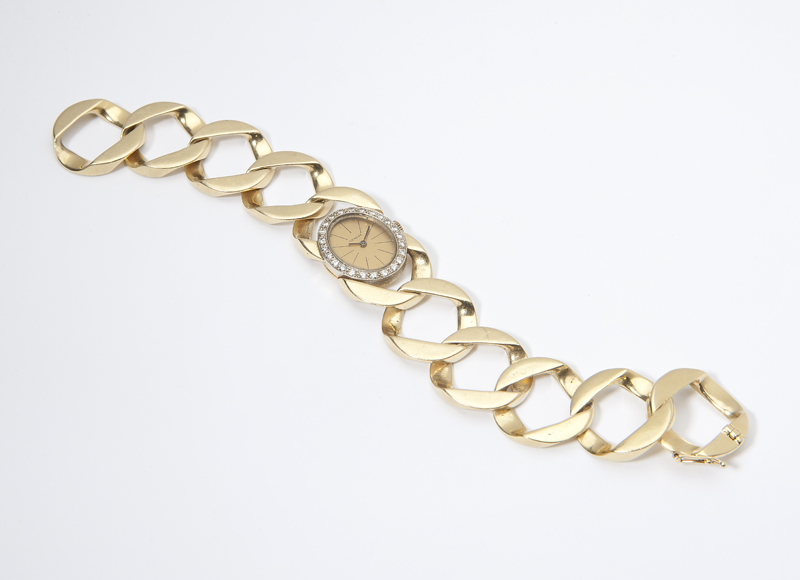 The oval brushed gold-tone dial