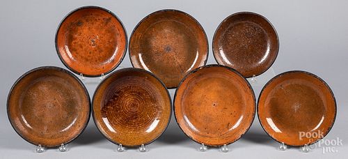 THIRTEEN REDWARE PLATES AND SHALLOW