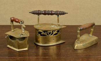 Three antique brass irons, one with