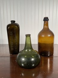 Three antique glass bottles: Avan