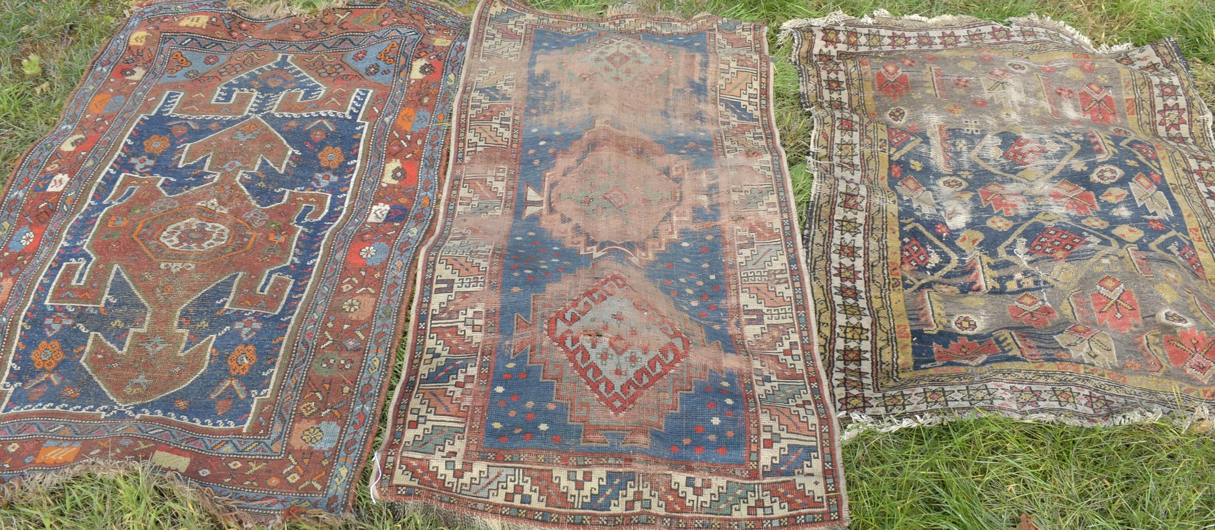 THREE ANTIQUE WORN SCATTER RUGS.