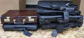 THREE BLACK VINYL SUITCASES, L