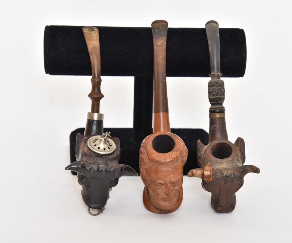 Three carved smoking pipes,
