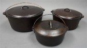 THREE CAST IRON COVERED POTS,