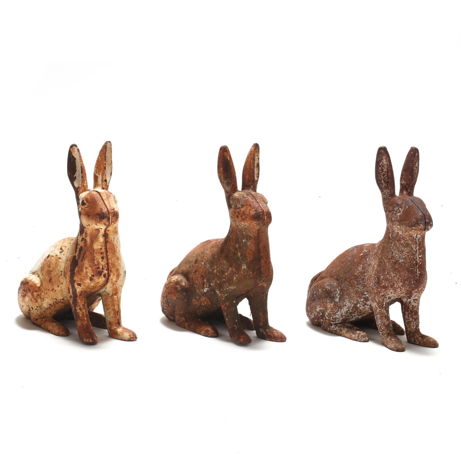 THREE CAST IRON GARDEN RABBITSThree