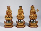 THREE CHINESE CARVED AND GILT