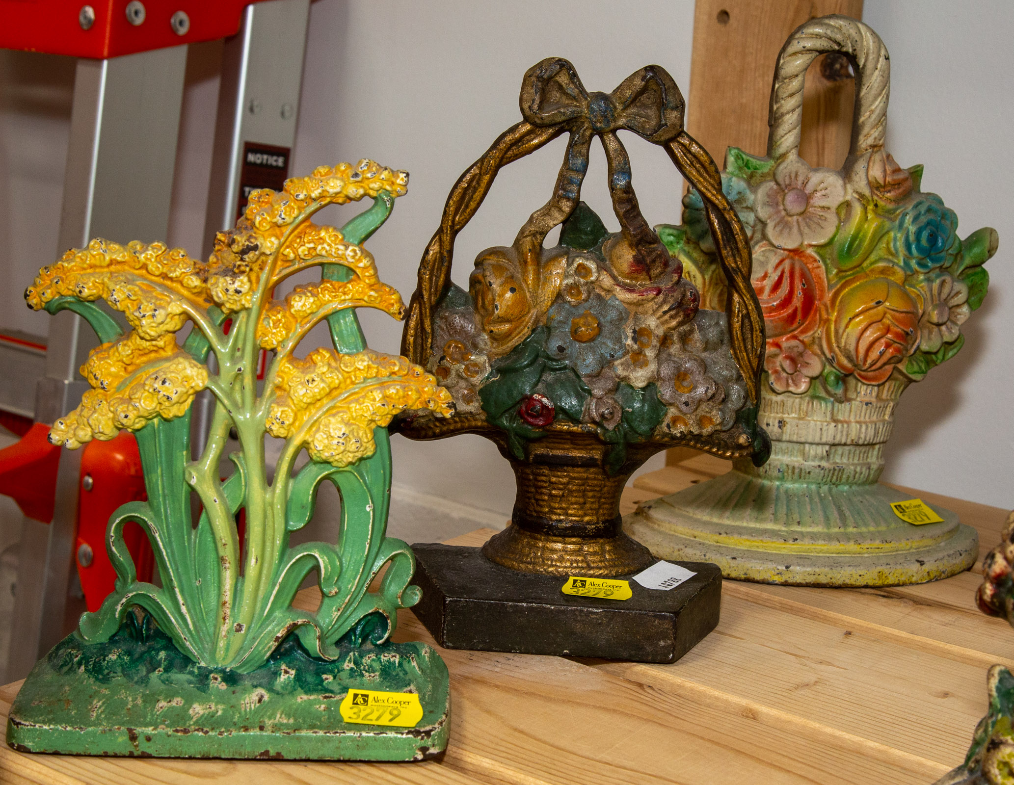THREE FLORAL CAST IRON DOOR STOPS