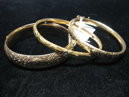 Three gold bangles all etched