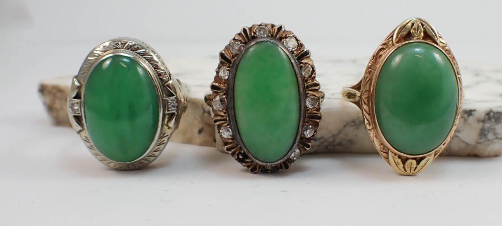 THREE GREEN JADE AND GOLD RINGS,