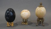 THREE HARDSTONE EGGS ON STANDS