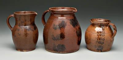 Three redware pitchers, all with