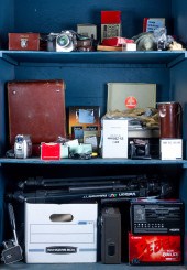 THREE SHELVES OF CAMERAS AND C
