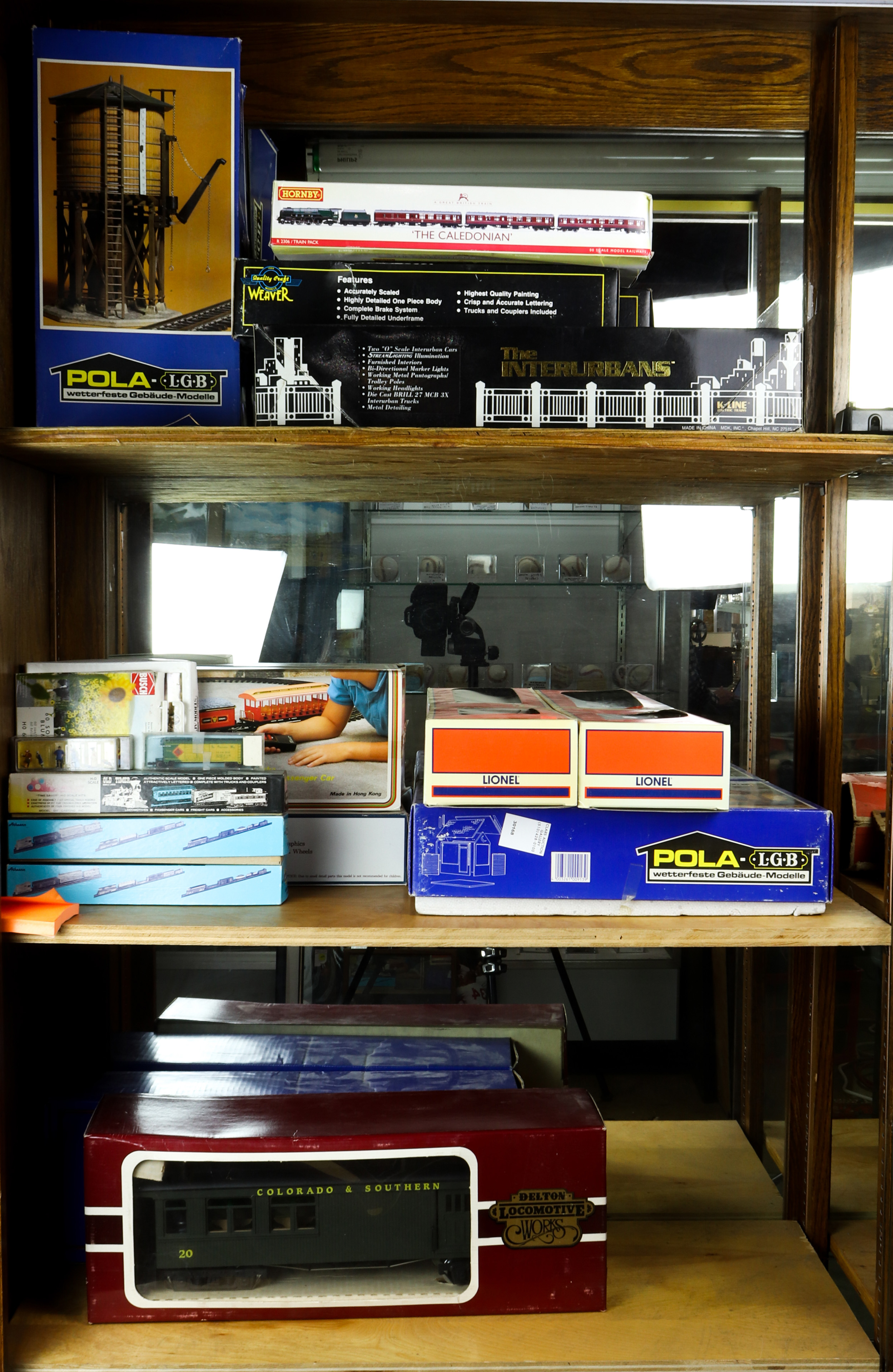 THREE SHELVES OF MODEL TRAINS IN