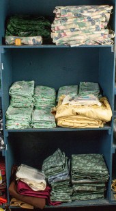 THREE SHELVES OF TABLE LINENS