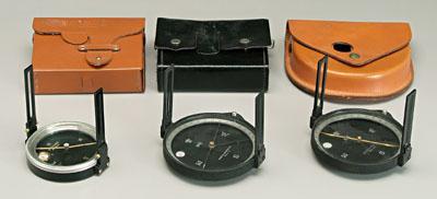 Three surveying compasses: one