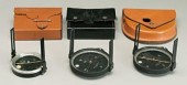 Three surveying compasses: one