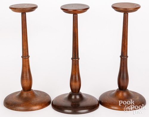 THREE TURNED WALNUT WIG STANDS,