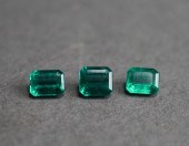 THREE UNMOUNTED EMERALD-CUT EM