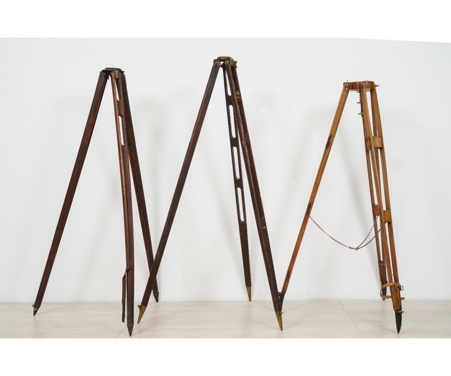 Three wood transit tripods, one